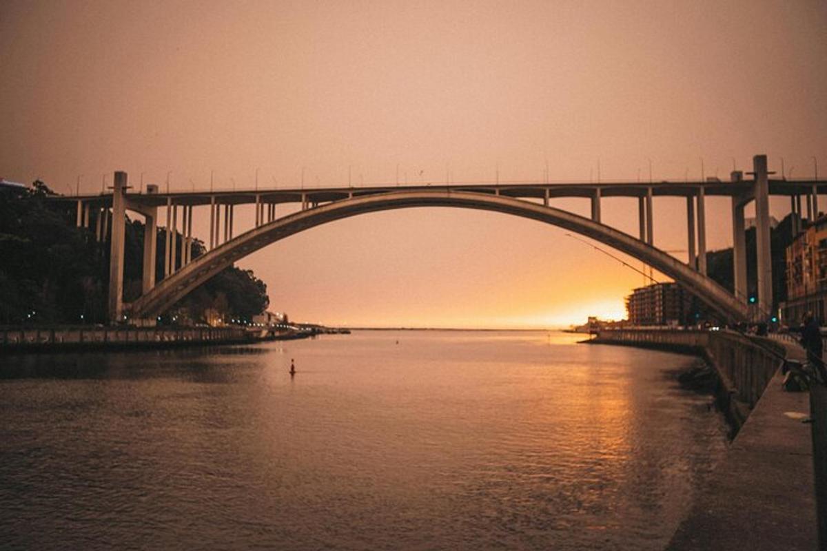 un ponte sopra uno specchio d'acqua con il sole che tramonta