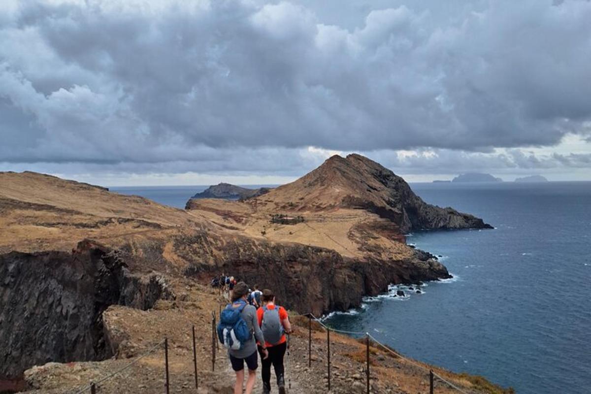 um grupo de pessoas caminhando em um penhasco perto do oceano