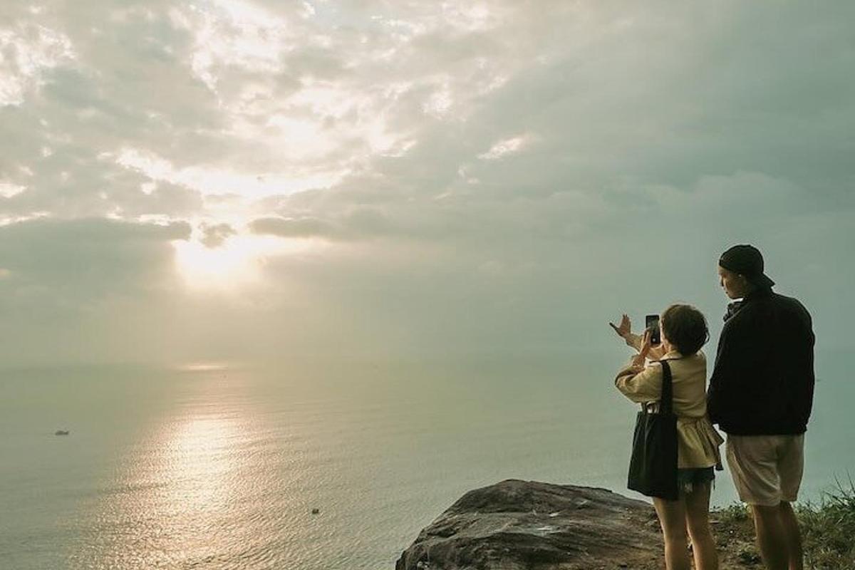 un uomo e una donna che scattano una foto dell'oceano