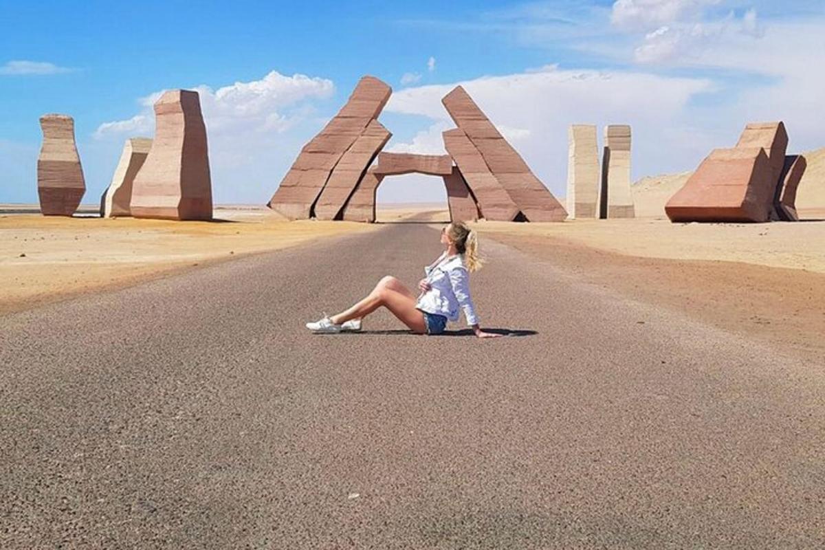una donna seduta sulla strada davanti a un monumento