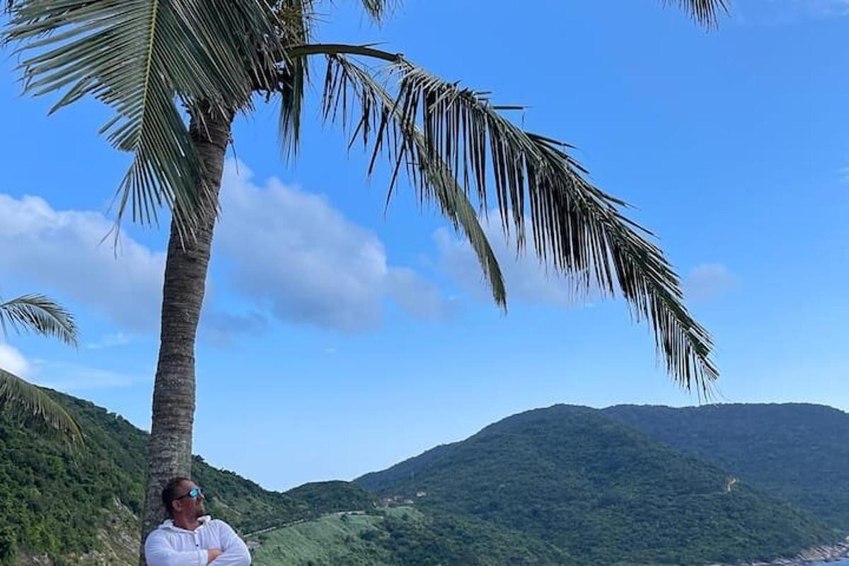 un hombre sentado junto a una palmera