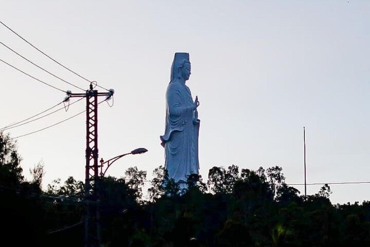 en stor statue av en kvinne som står på himmelen