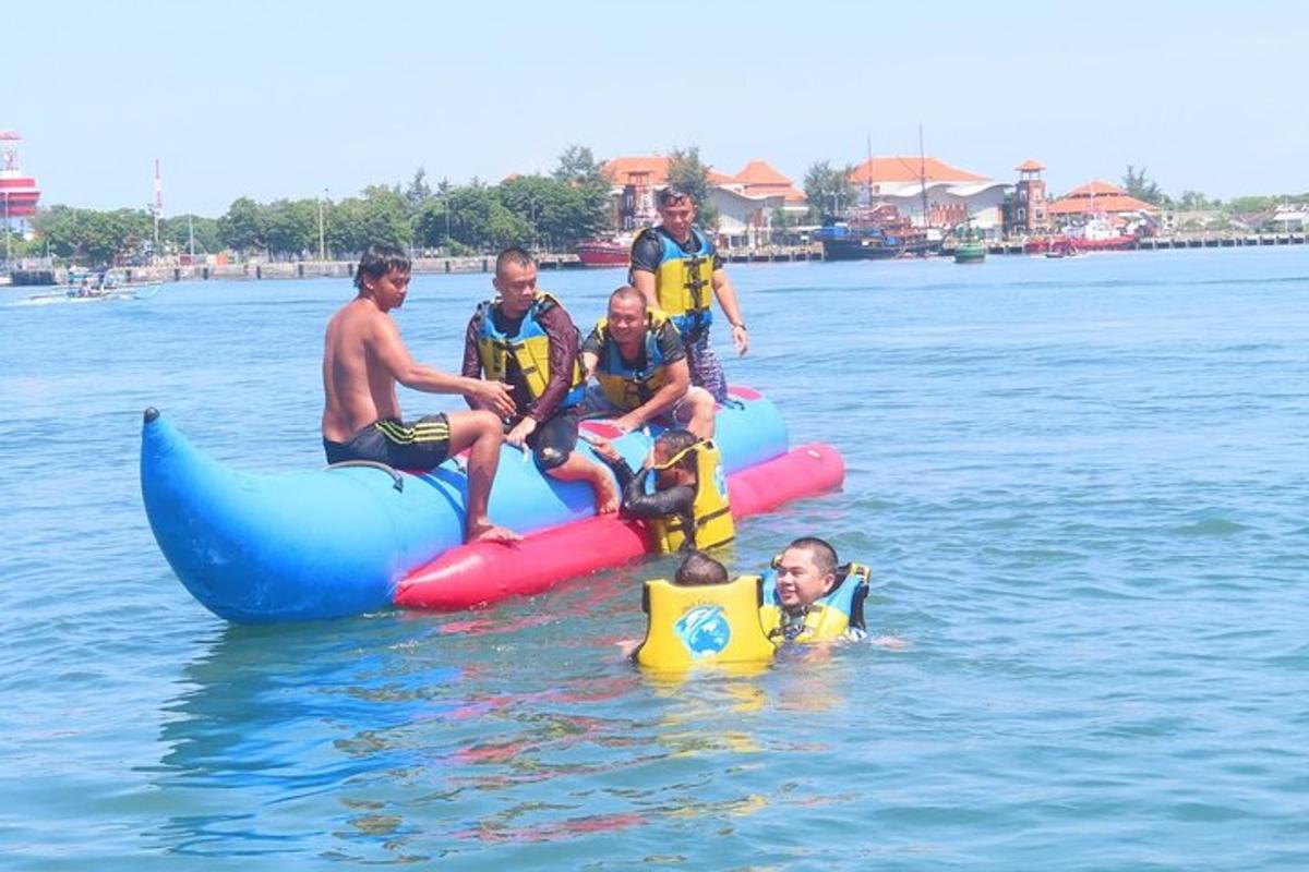 un grup de oameni în apă pe un obiect gonflabil