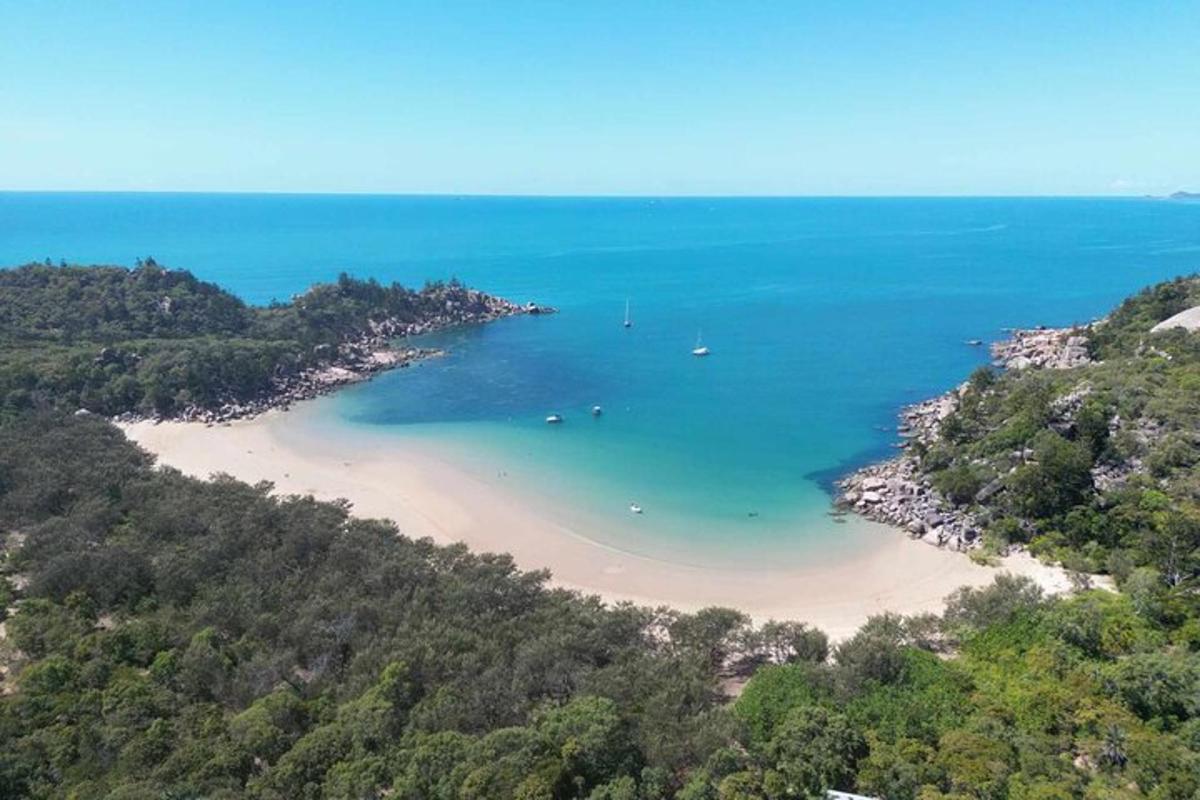 an aerial view of a beach with boats in the water