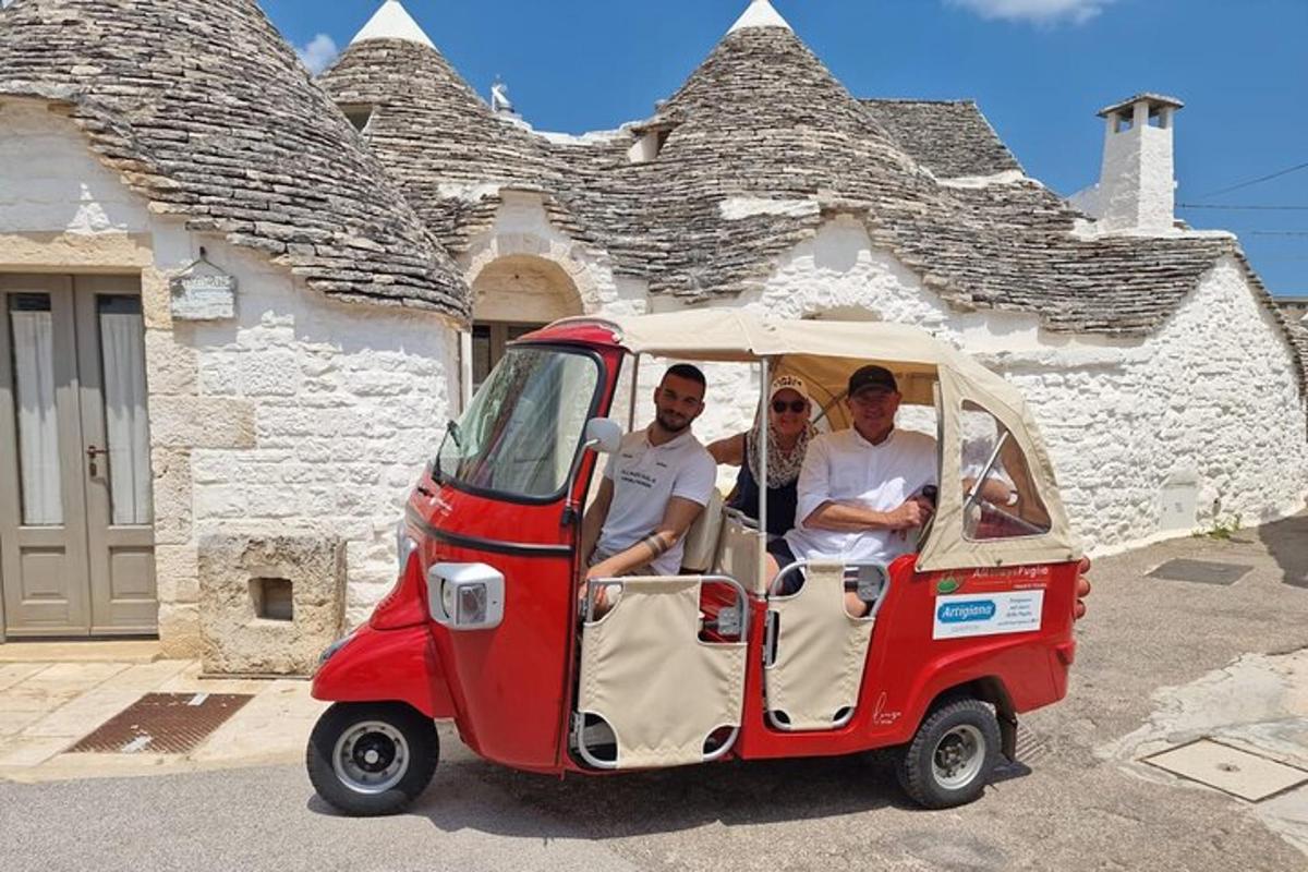 Un grupo de tres personas viajando en un coche pequeño.