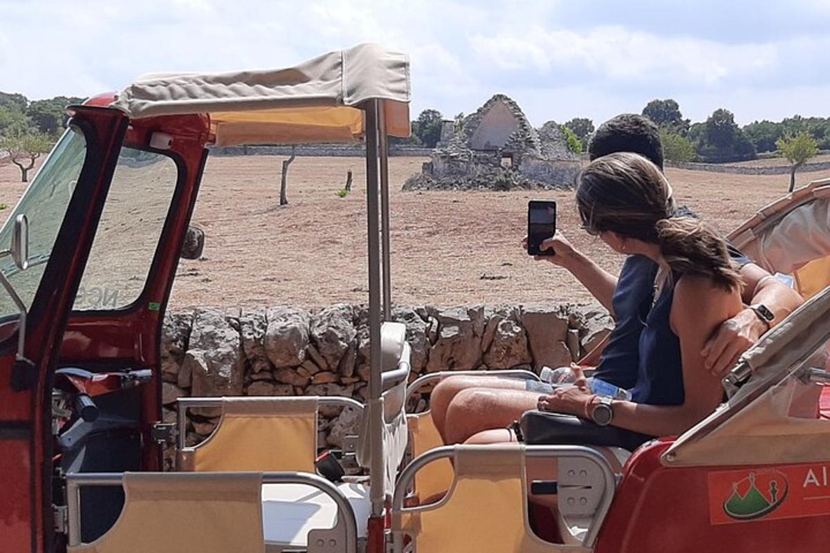 a woman sitting in the back of a vehicle taking a picture