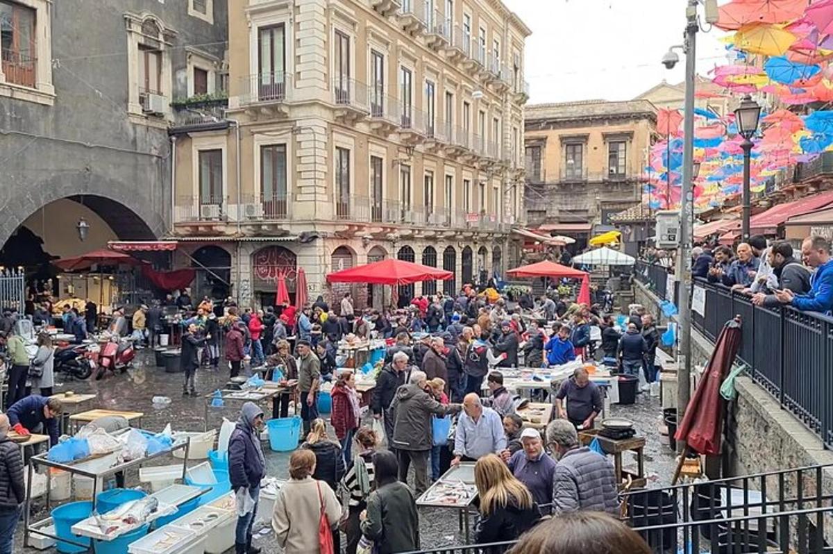 Una multitud de personas caminando por una calle con mesas.