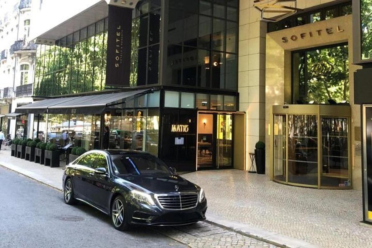um carro preto estacionado em frente a um prédio