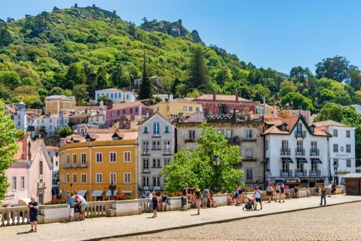 um grupo de pessoas caminhando em uma rua em frente a uma cidade
