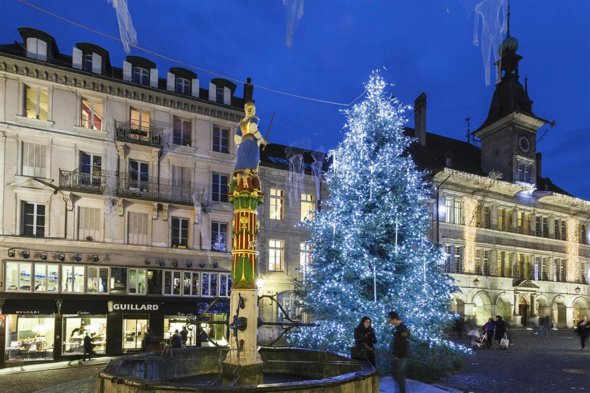 un arbre de Nadal davant d'un edifici amb llums