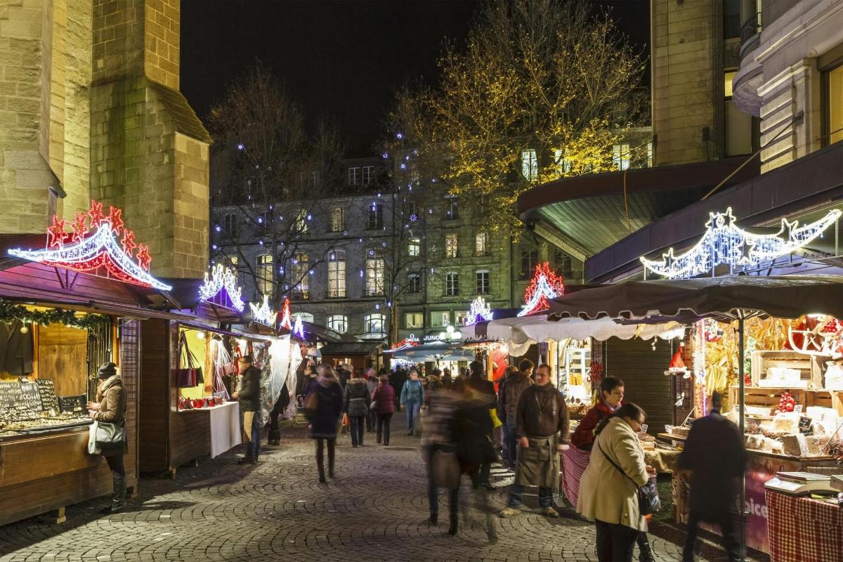 una multitud de gent caminant per un mercat de Nadal a la nit