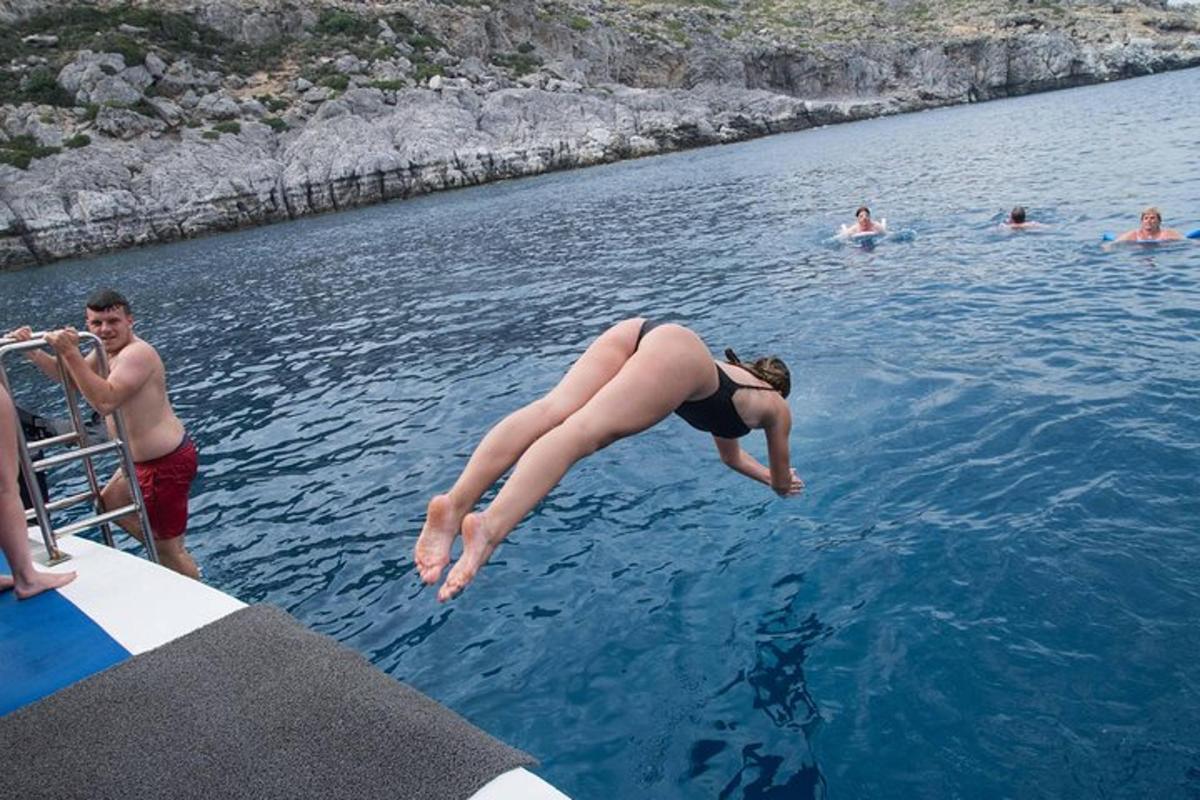 una mujer saltando al agua desde un bote