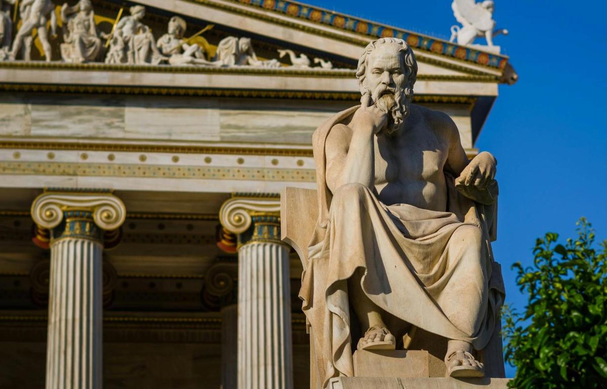 una statua di un uomo in piedi davanti a un edificio