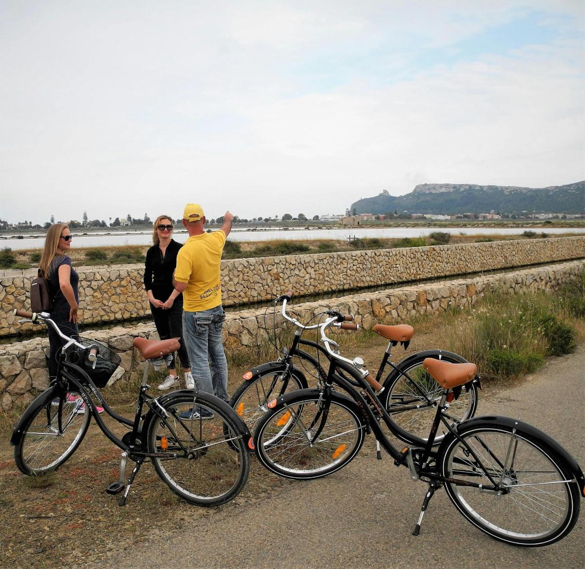 a man and two women standing next to bikes