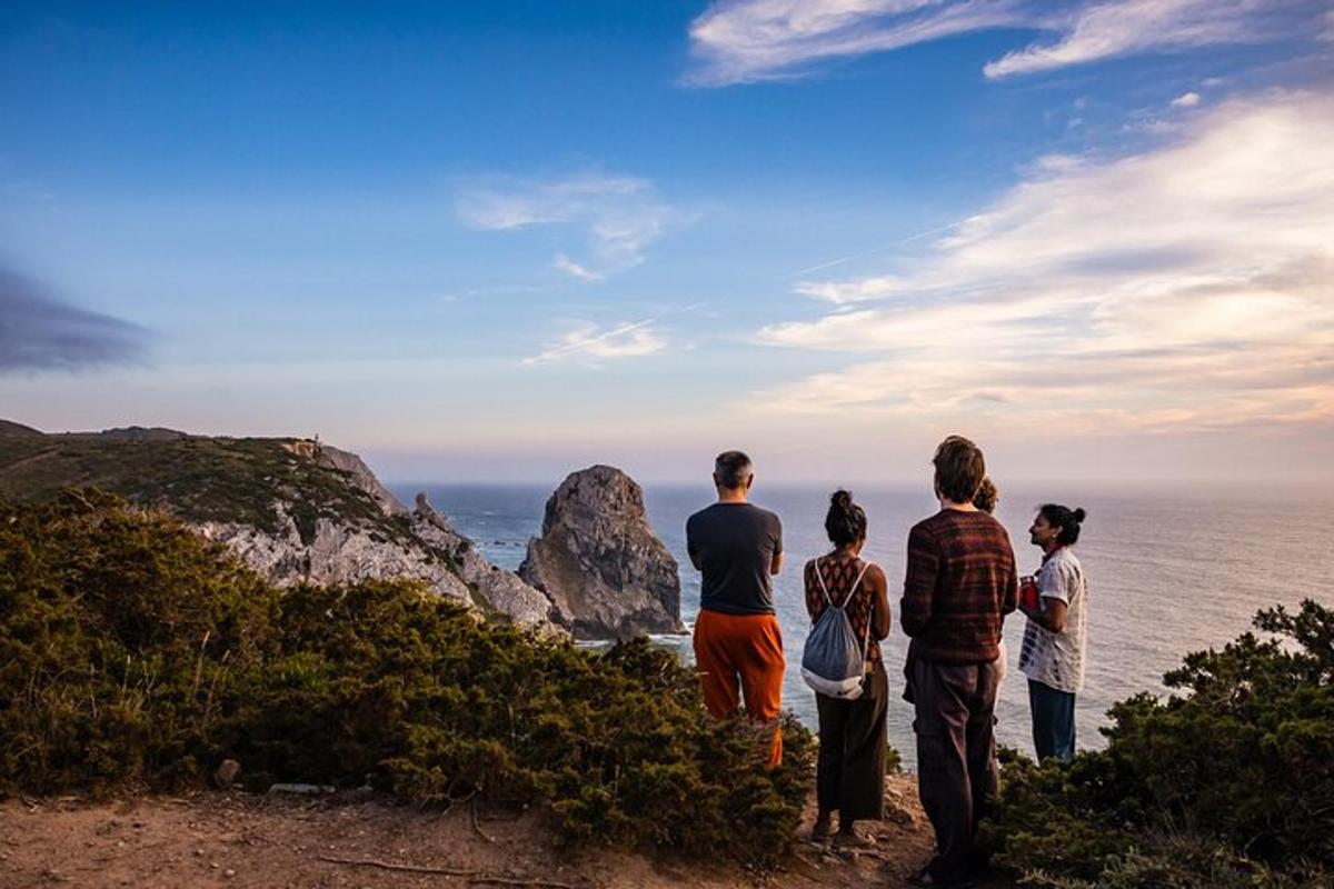 sekumpulan orang berdiri di atas bukit melihat lautan