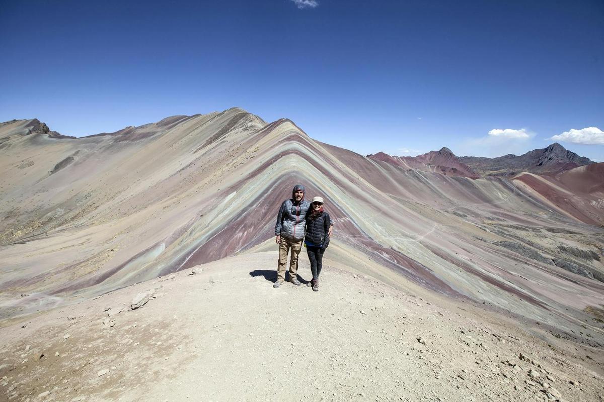due persone in piedi sulla cima di una montagna