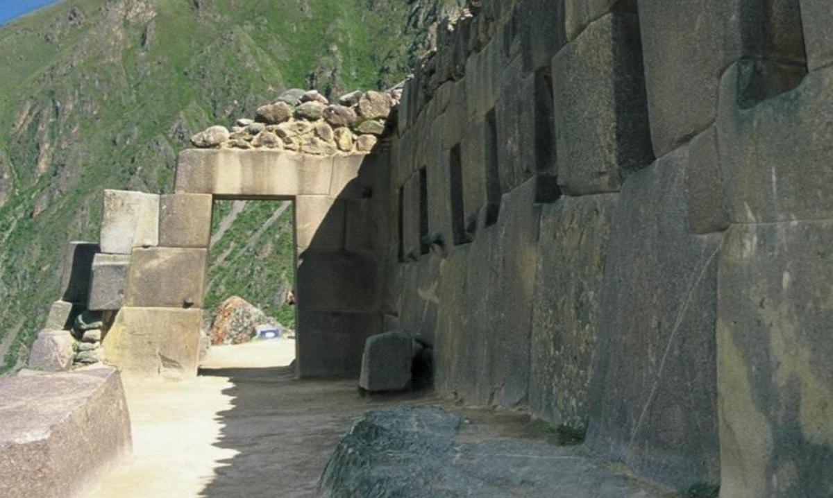un mur de pedra amb un túnel a la muntanya