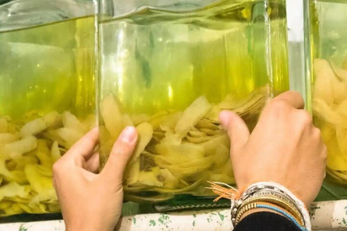 a person holding their hands up to a container of food