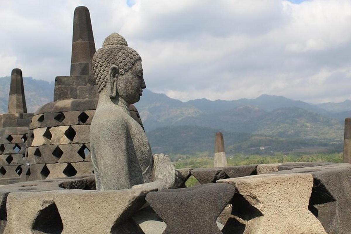 patung di atas gedung dengan latar belakang pegunungan
