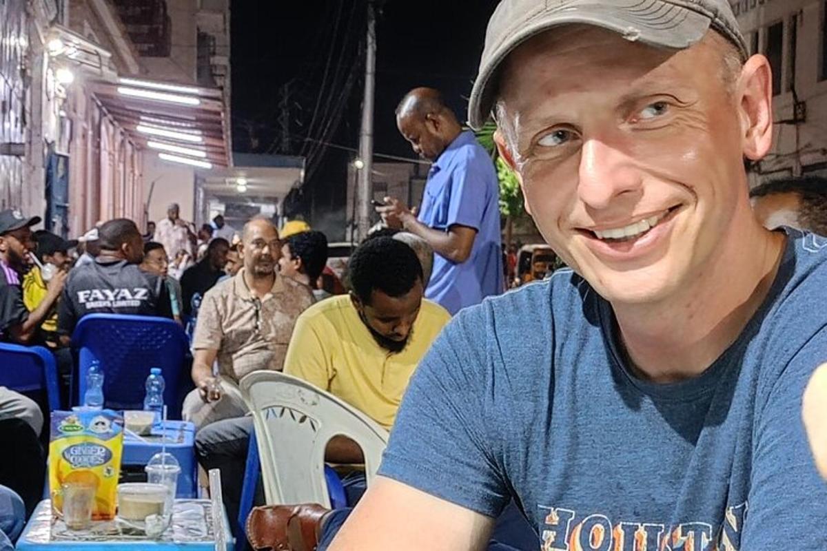 a man in a blue shirt sitting at a table
