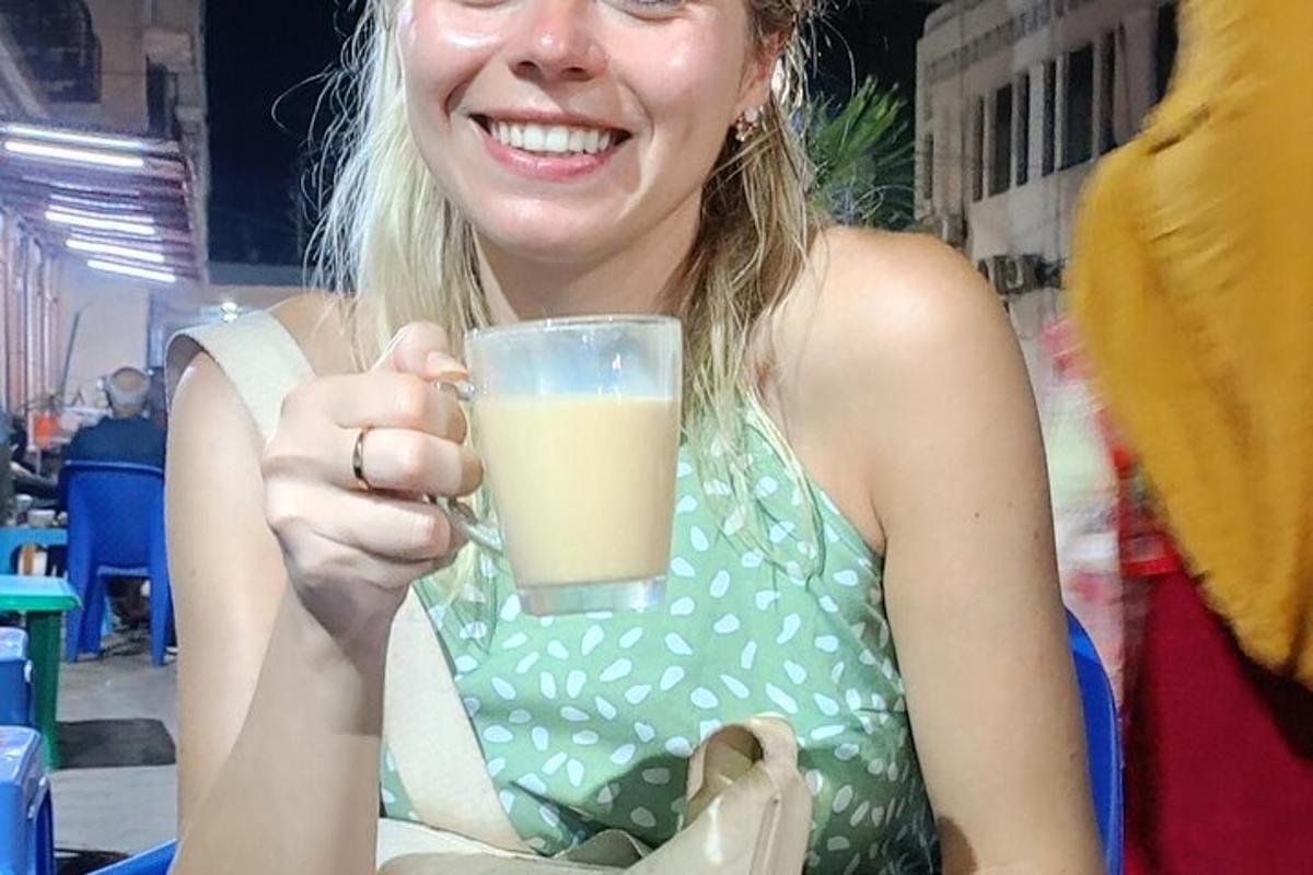 a woman holding a glass of orange juice