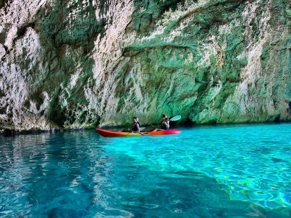 Dos personas en kayaks en el agua junto a un acantilado