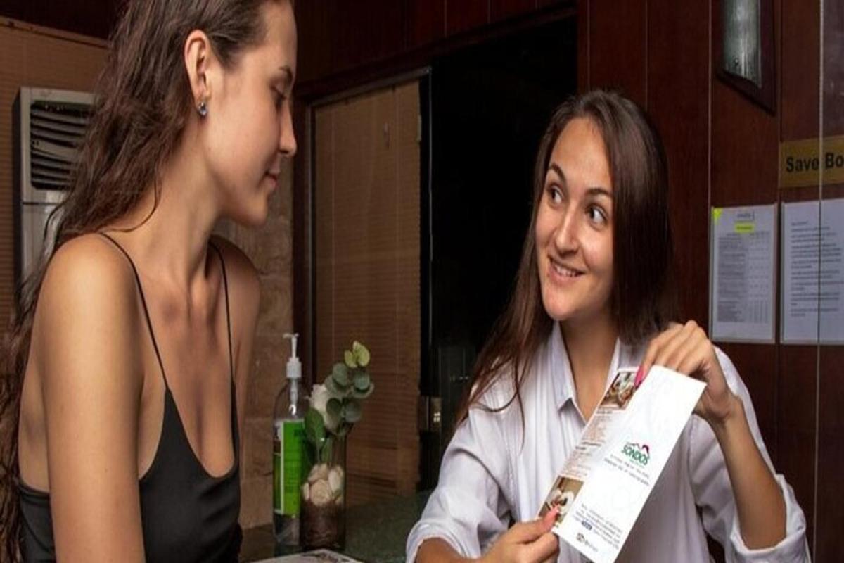 due donne sedute a un tavolo che parlano tra loro