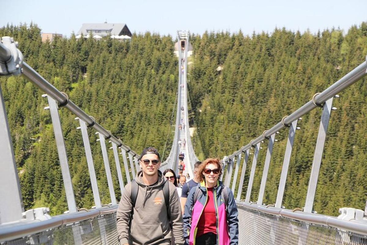 skupina lidí stojící na visutém mostě
