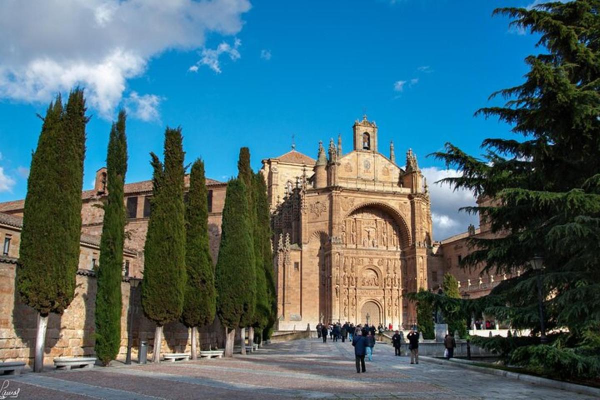 a large building with a tower and trees in front