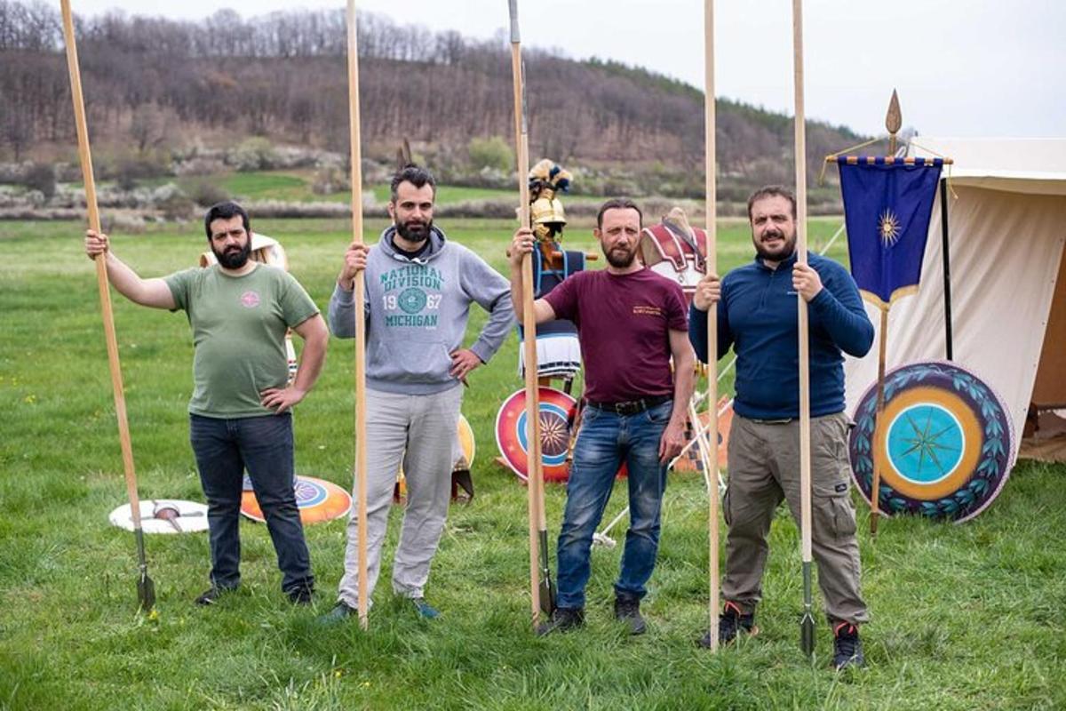 un grup de bărbați care stăteau pe un câmp ținând sulițe