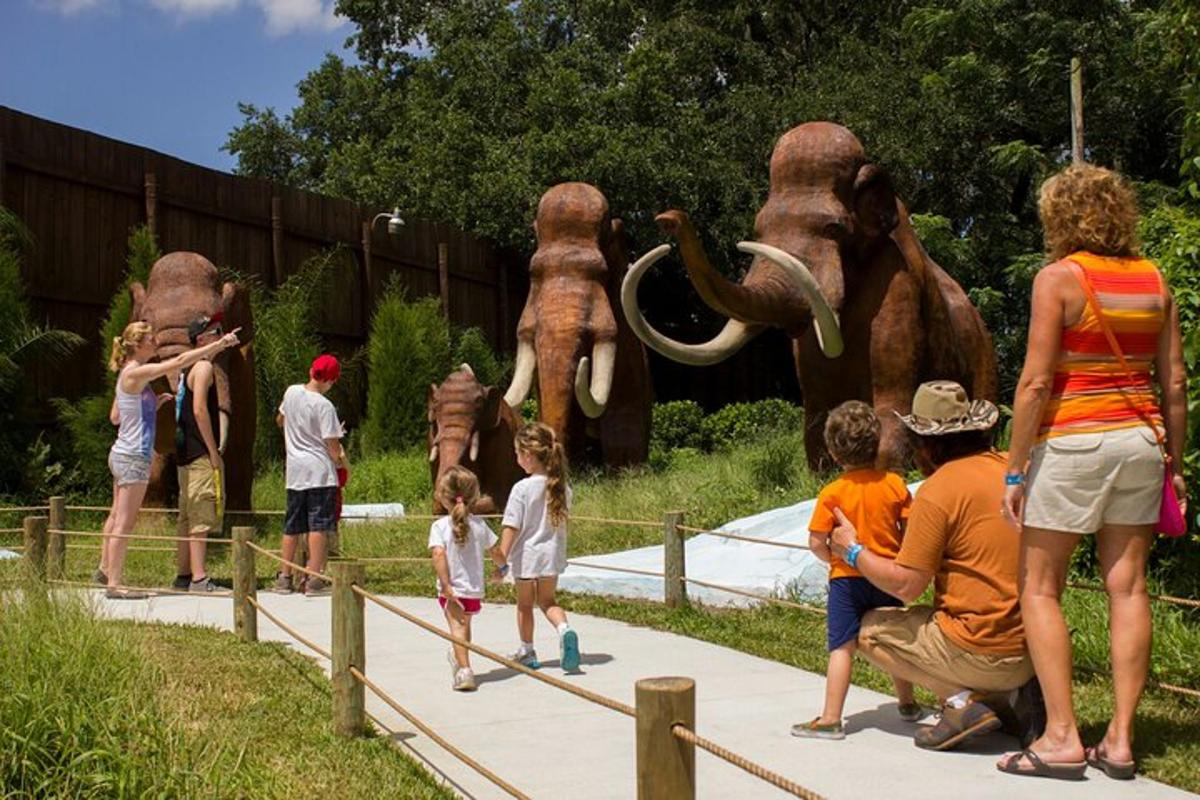 a group of people standing in front of statues of elephants