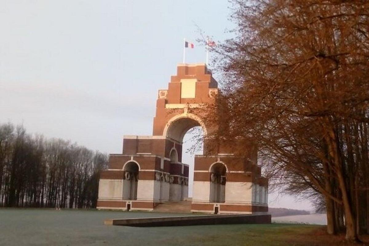 a building with an arch in the middle of a field