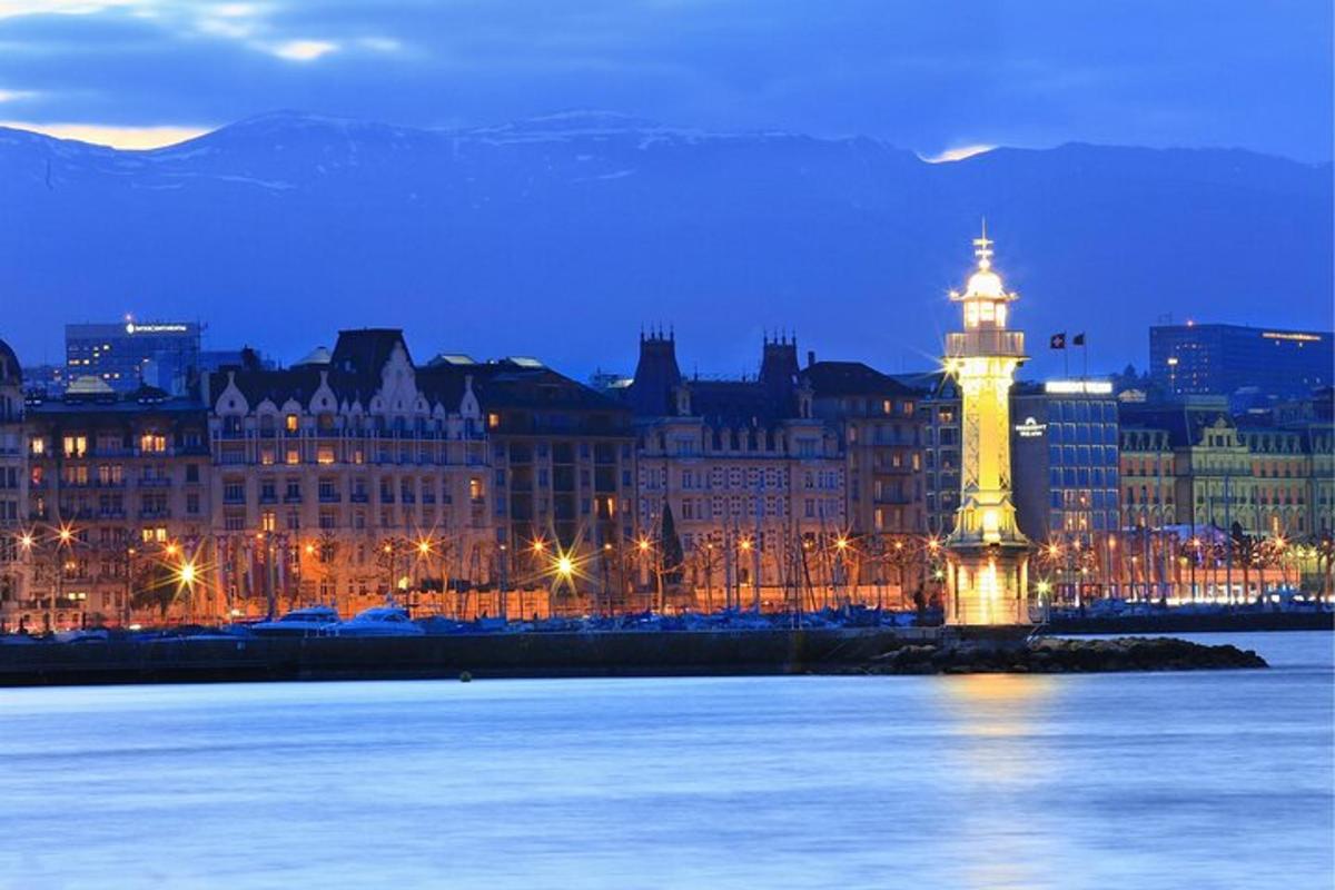 a lit up lighthouse in front of a city at night