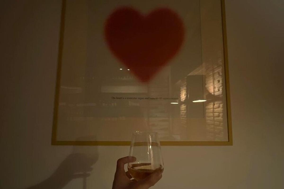 slika osebe, ki drži kozarec vina pred srcem