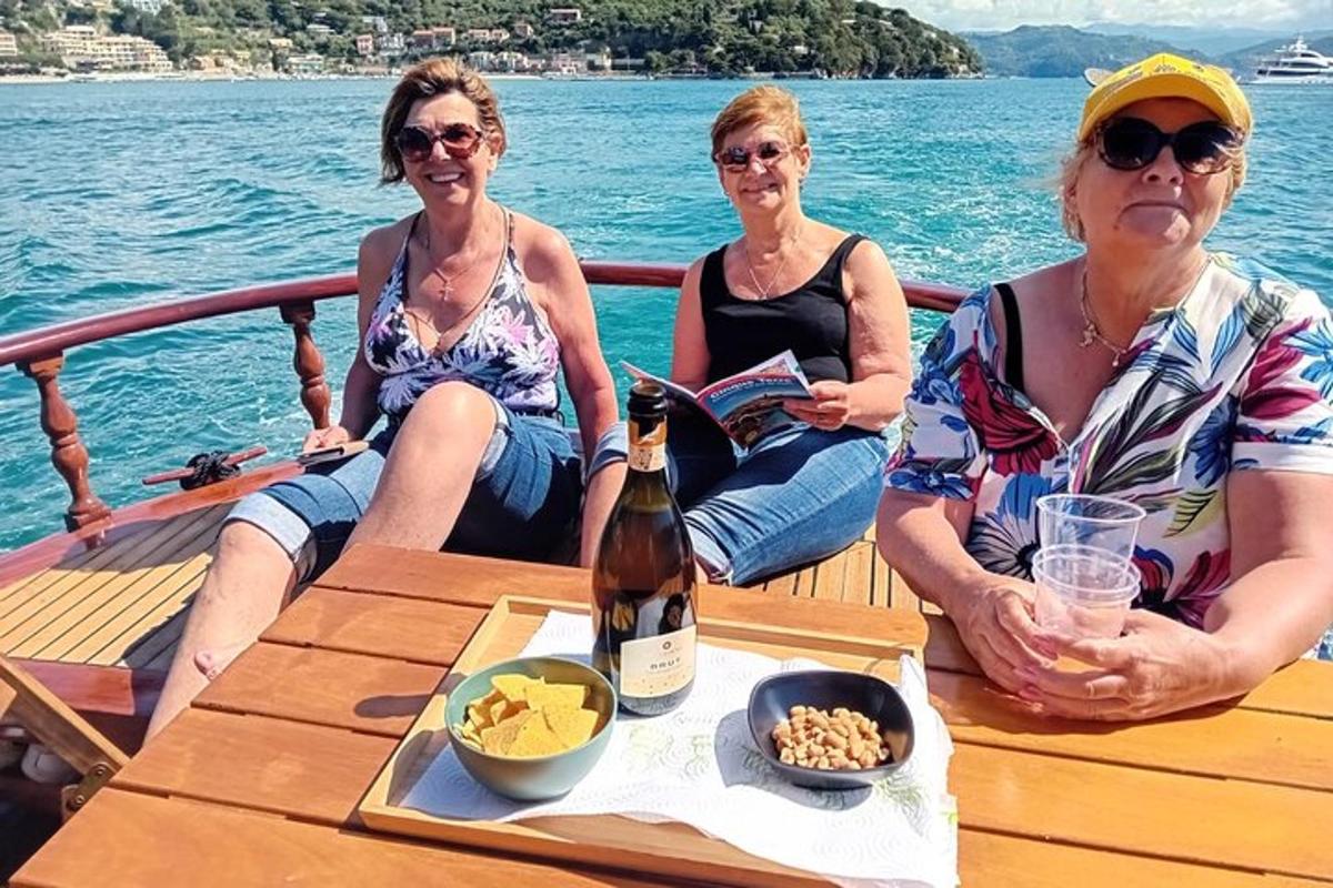 Τρεις γυναίκες κάθονται σε μια βάρκα με ένα μπουκάλι κρασί