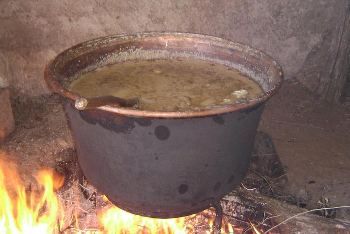 a large pot of soup sitting on a fire