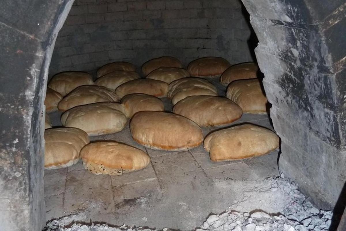 a batch of buns are coming out of an oven