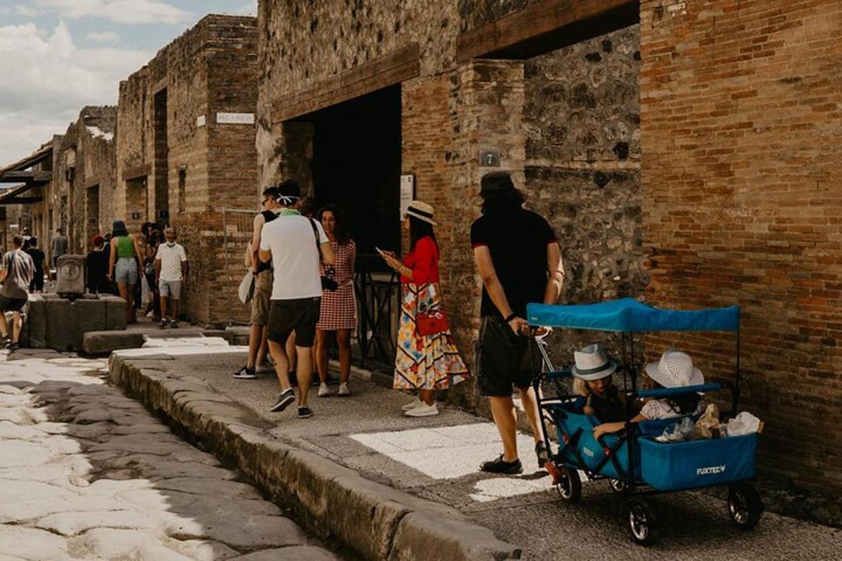 μια ομάδα ανθρώπων που περπατούν σε έναν δρόμο με ένα παιδικό καρότσι