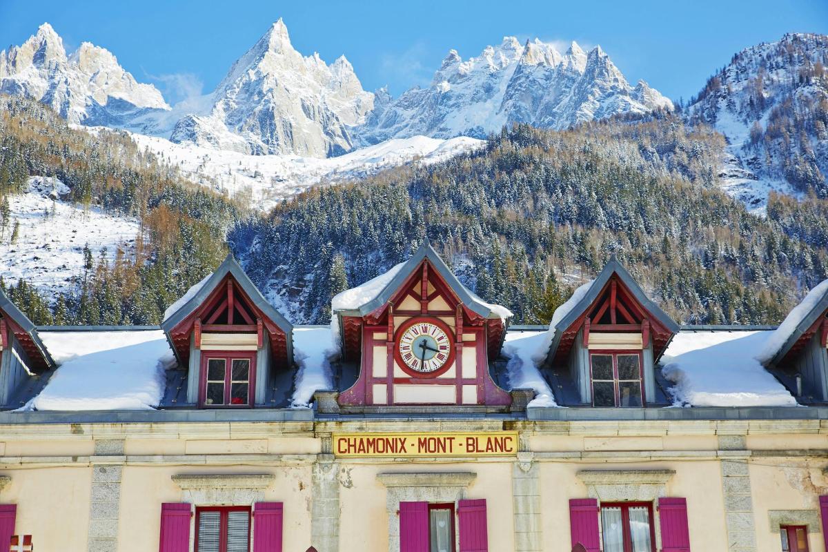 a building with a clock on top of it with mountains