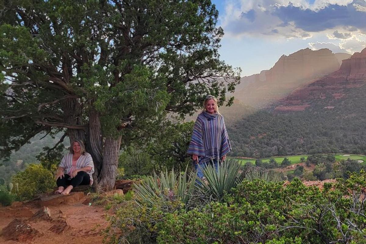 duas mulheres em pé em uma colina com vista para o Grand Canyon