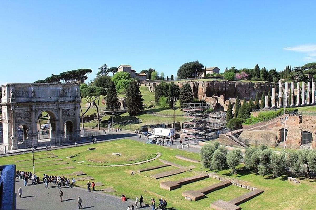 a group of people walking around a park with ruins