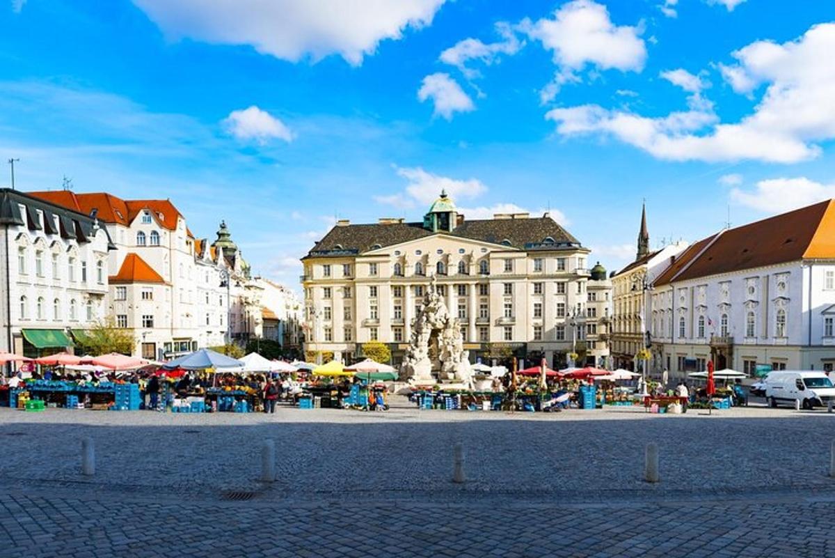 a group of buildings with tables and umbrellas in a city