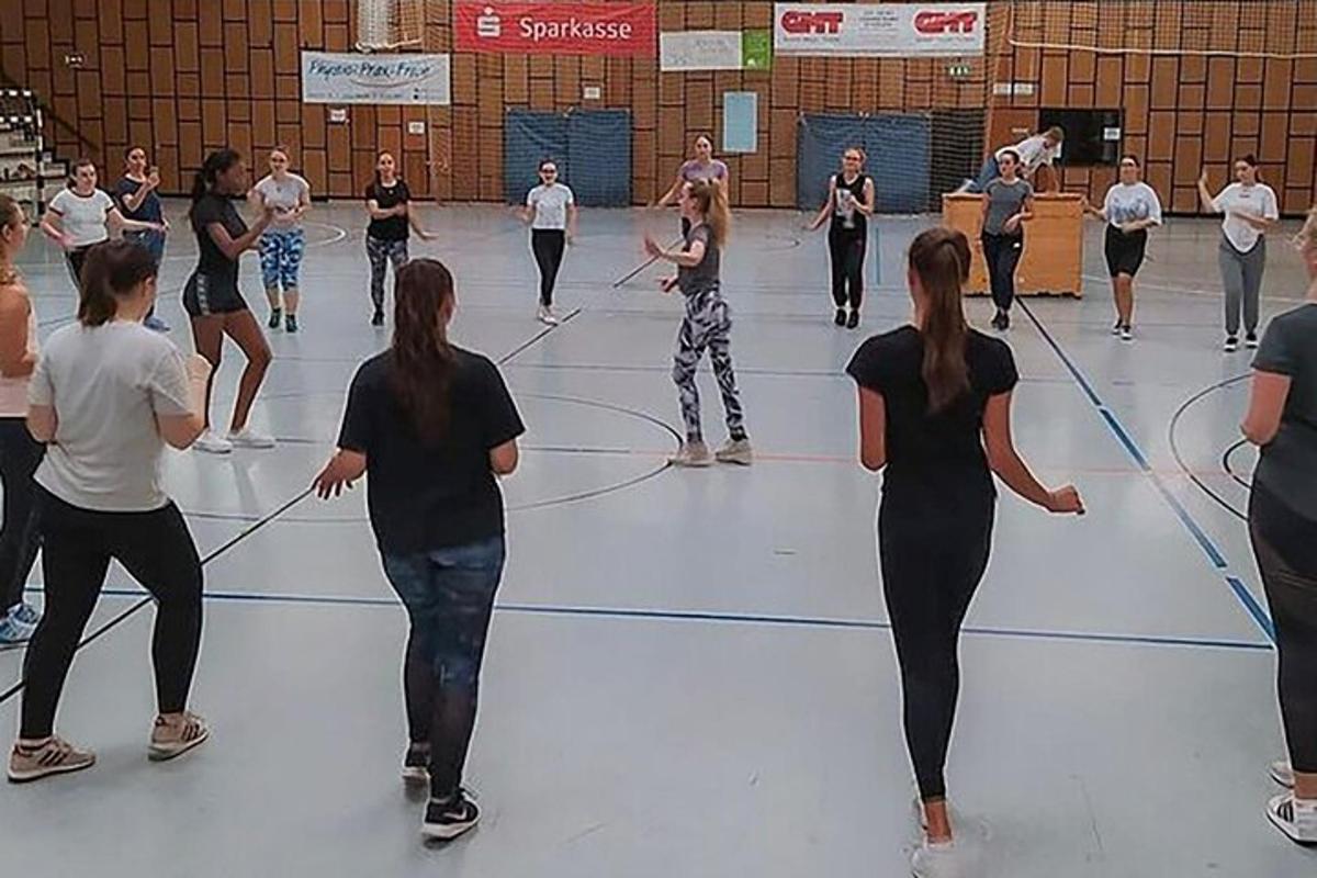 un grup de persones ballant en una pista de bàsquet