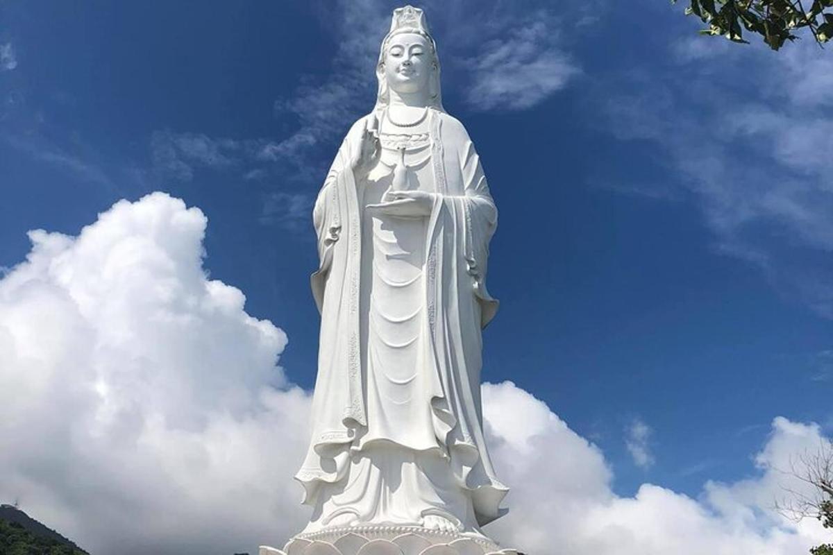 Una gran estatua blanca frente a un cielo nublado