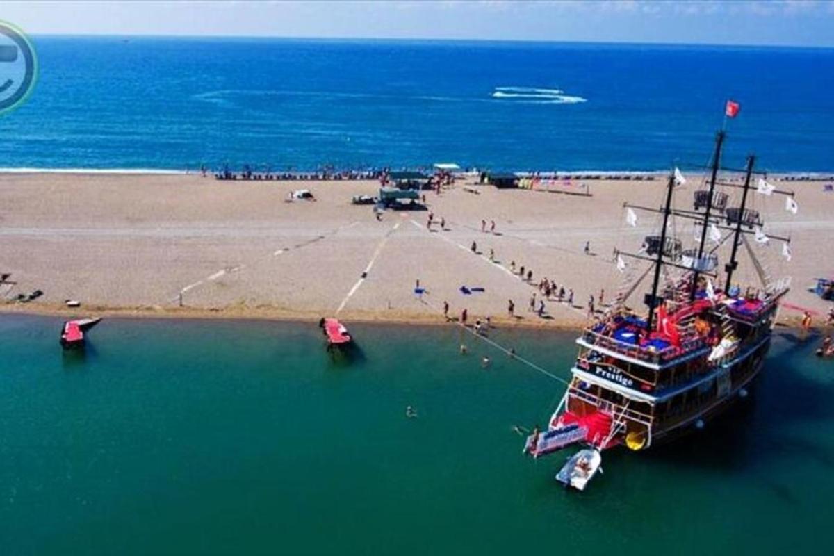a large boat in the water next to a beach