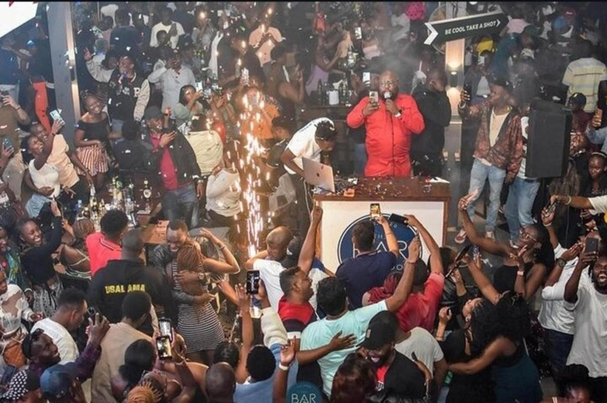 a crowd of people standing around a man on a stage