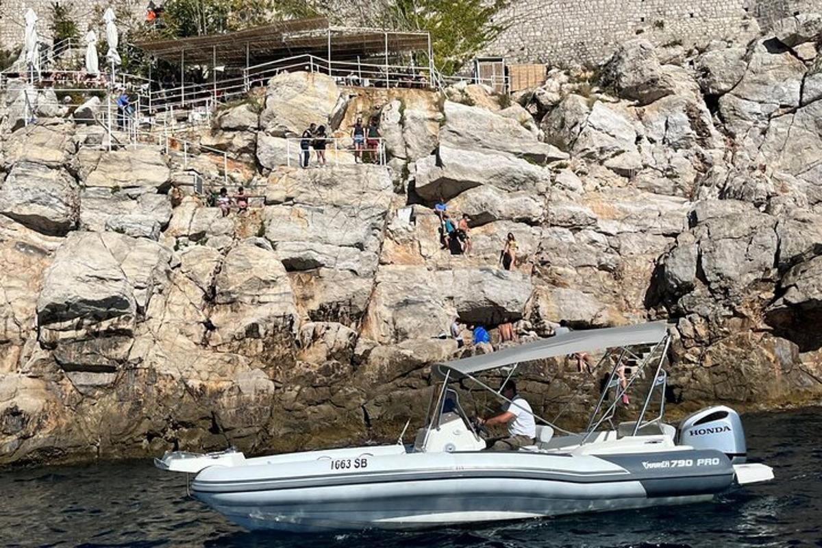 un vaixell a l'aigua al costat d'una paret de roca