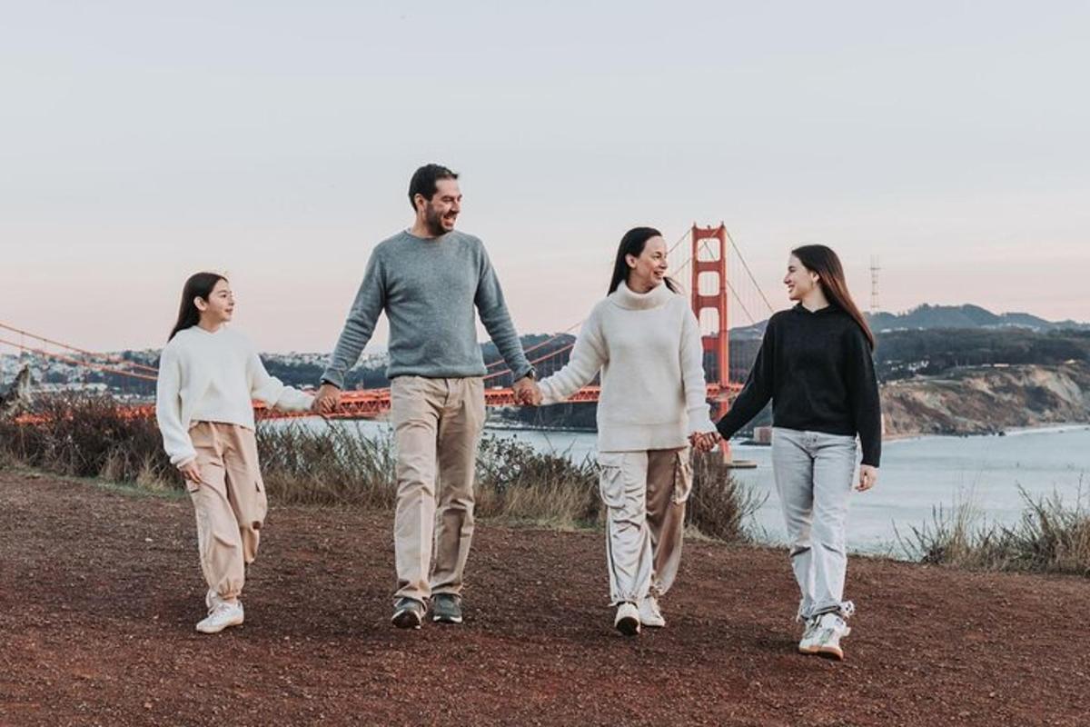 Un grupo de tres personas caminando frente al puente Golden Gate