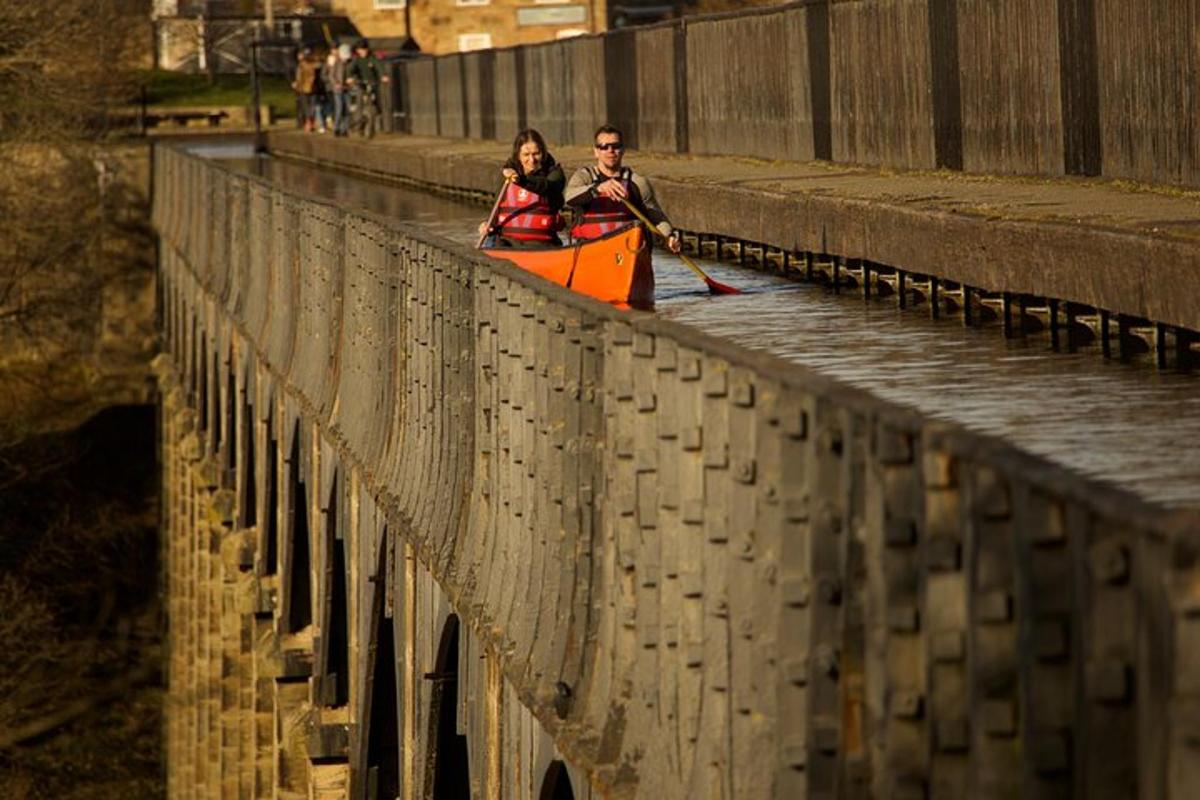 a man and woman in a kayak on a bridge