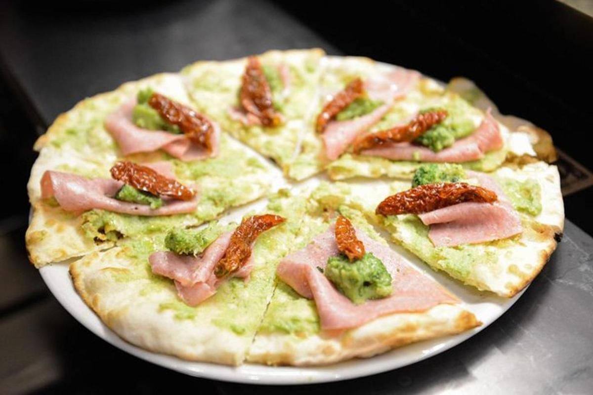 pizza dengan ham dan brokoli di atas pinggan